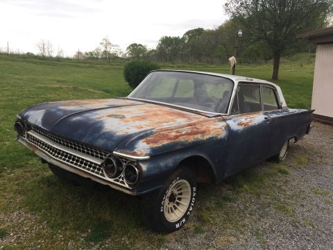 1961 Ford Galaxie - This 1961 Ford Galaxie shows significant rust and wear, with its original blue paint faded and peeling.