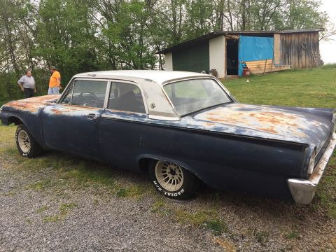 1961 Ford Galaxie - This 1961 Ford Galaxie sedan is seen outdoors with significant rust and wear on its body.