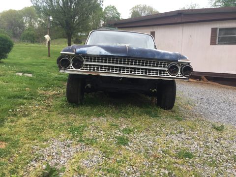 1961 Ford Galaxie - A 1961 Ford Galaxie is shown from the front, with its distinctive grille and dual headlights visible.