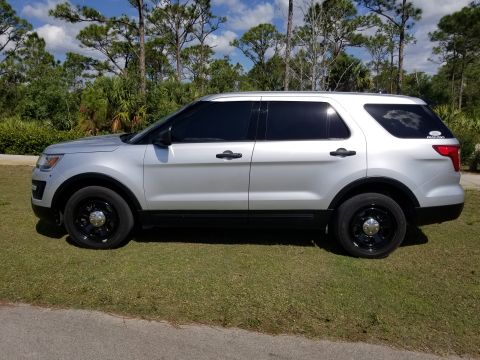 2017 Ford Explorer - Side profile of a silver 2017 Ford Explorer with black wheels and tinted windows.