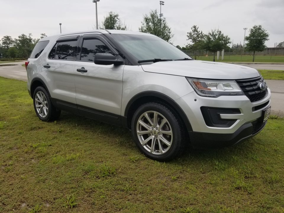Silver SUV parked on grass, front 3/4 view. Visible text: SUPERMOTORS www.supermotors.net