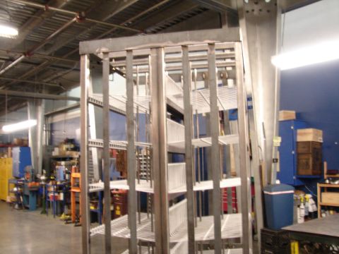 1973 Ford Ranchero - A metal shelving unit is shown in a workshop setting with various tools and equipment in the background.