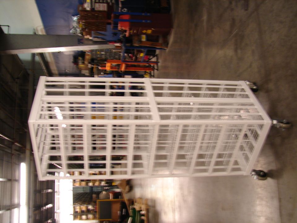 White metal cage on wheels in a warehouse setting