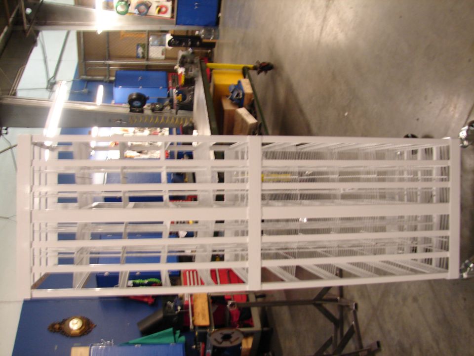 white metal shelving unit in a workshop with tools and cabinets in background