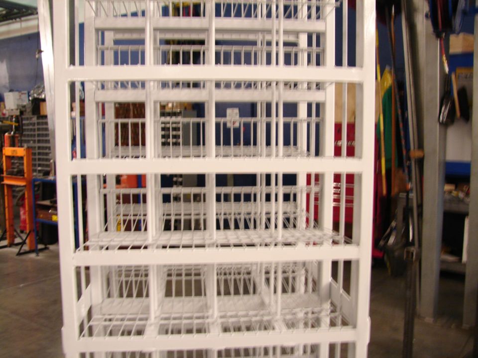 White metal shelving unit with multiple compartments, viewed from the front in a workshop setting
