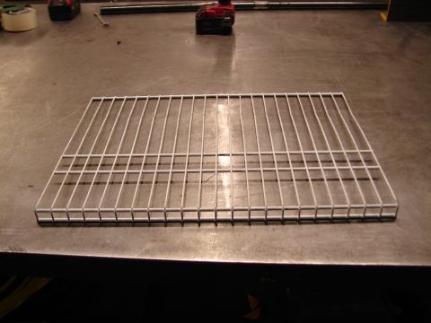 1973 Ford Ranchero - A white wire rack sits on a metal surface, with tools visible in the background.