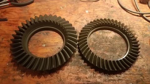 1985 Ford Bronco - Differential ring gears are shown on a workbench, possibly for a Ford Bronco.