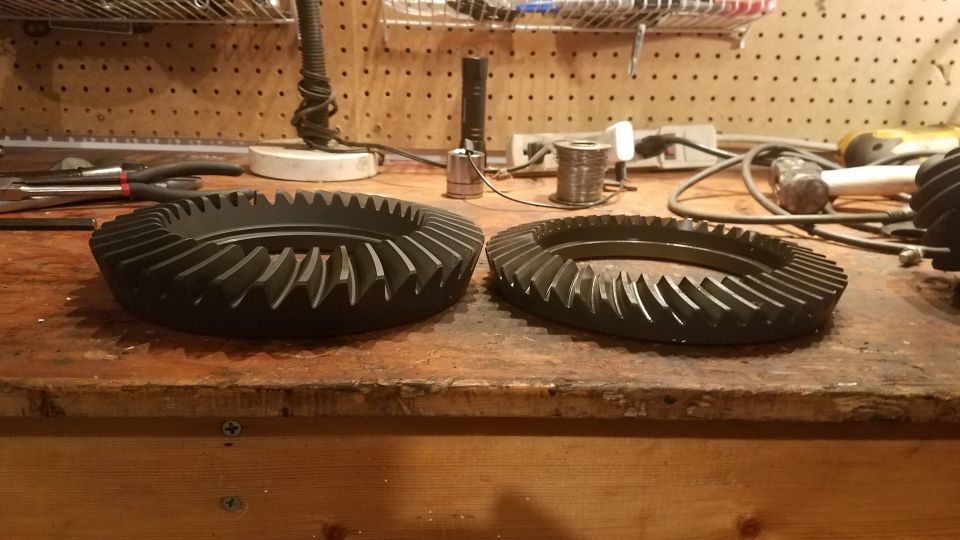 two ring gears on a workbench with tools in the background