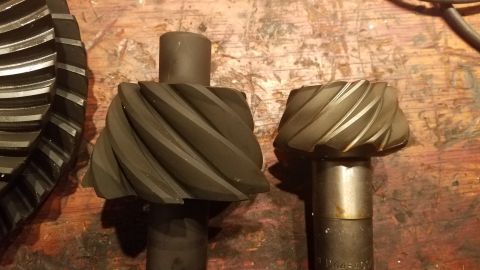 1985 Ford Bronco - Comparison of two differential gears, likely for a vehicle's drivetrain, shown on a workbench.