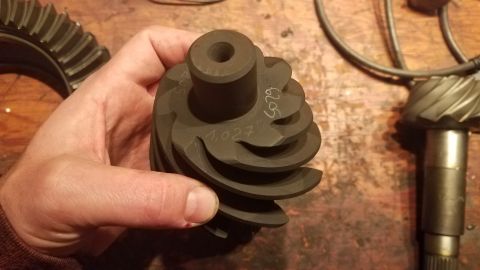 1985 Ford Bronco - Close-up of differential gears, one held in a hand, with visible part numbers.