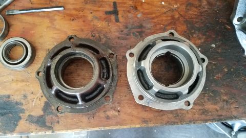 1985 Ford Bronco - Comparison of a used differential housing next to a cleaned or new one on a workbench.