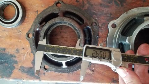 1985 Ford Bronco - Measuring a differential housing part with digital calipers, showing a reading of 26.50 mm.