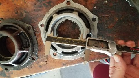 1985 Ford Bronco - A digital caliper measures a metal part, displaying a reading of 29.77. The part appears to be a component of an engine or drivetrain, rest…