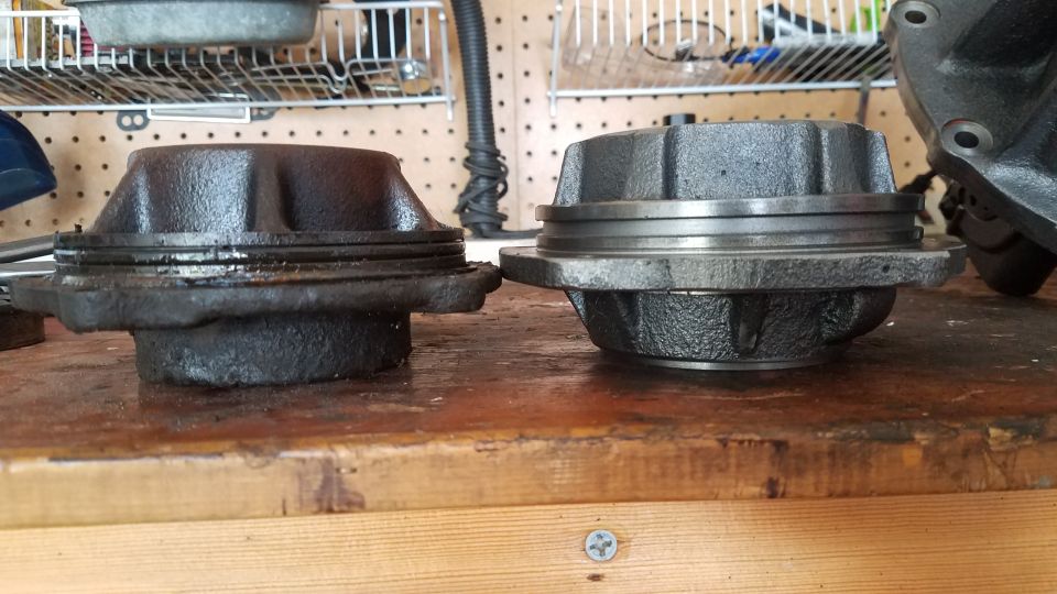 Two automotive hub assemblies on a wooden workbench.