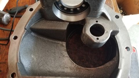 1985 Ford Bronco - A close-up view of the inside of a cast iron differential housing, likely from a 1985 Ford Bronco. A bearing is visible at the top, and the…