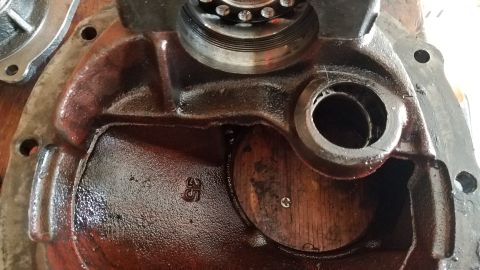 1985 Ford Bronco - A close-up view of the internal components of a heavily oiled, cast-iron differential housing. Visible markings include the number "35" sta…