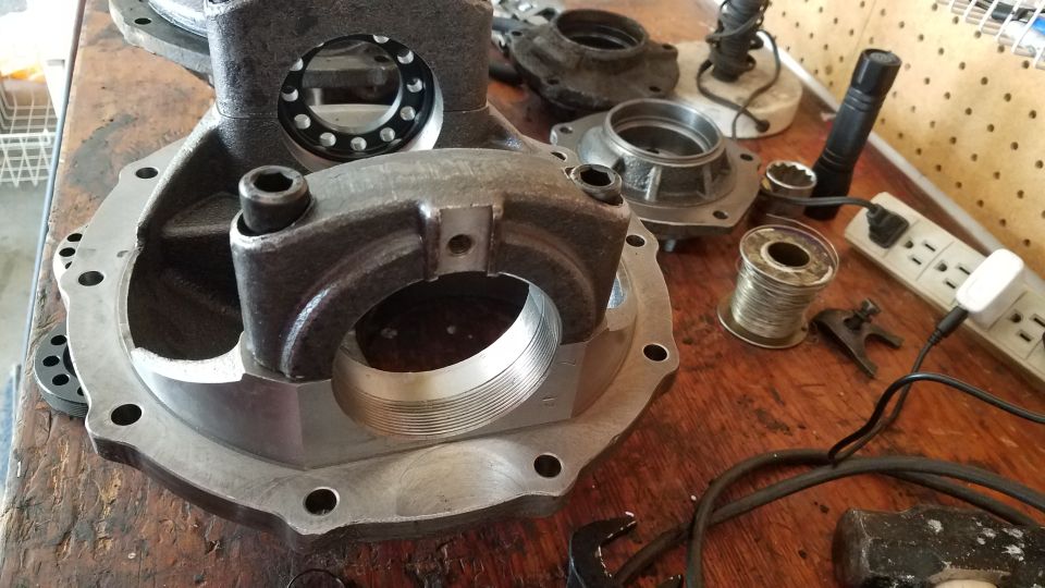 Differential housing and parts on a workbench.