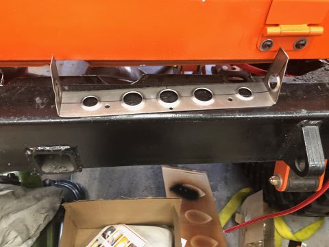 1992 Jeep Wrangler - A custom metal bracket with five circular cutouts is mounted to the black frame of an orange vehicle. The bracket appears to be a new modif…