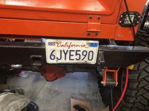 1992 Jeep Wrangler - A California license plate with the number 6JYE590 is mounted on the rear bumper of an orange Jeep. The license plate is dated OCT 2019.