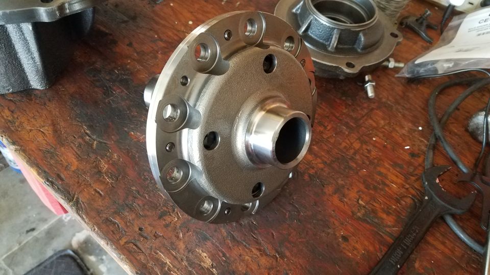Differential carrier and housing on a wooden workbench.