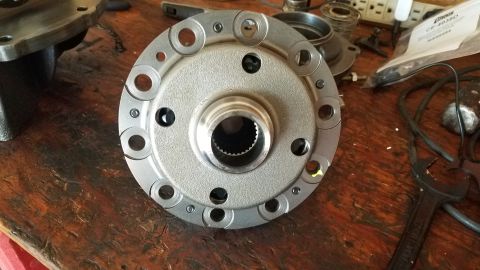 1985 Ford Bronco - A close-up view of a differential carrier with a splined input shaft. Several bolts and holes are visible around the perimeter of the carri…