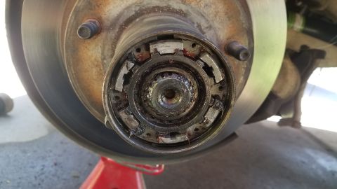 1985 Ford Bronco - A close-up view of a vehicle's wheel hub assembly, showing a manual locking hub mechanism with visible grease and wear.