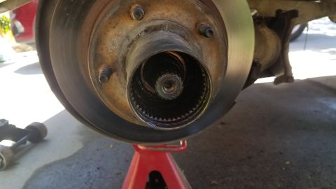 1985 Ford Bronco - Wheel hub and brake rotor assembly shown on a red jack stand.