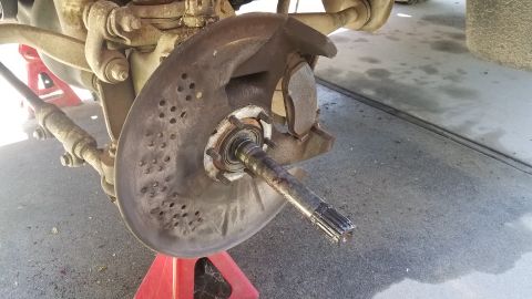 1985 Ford Bronco - Close-up of a vehicle's front wheel hub and brake assembly, likely undergoing maintenance.
