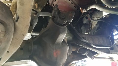 1985 Ford Bronco - This is an underside view of a vehicle's drivetrain, showing a differential housing and a universal joint connecting to a driveshaft. The d…