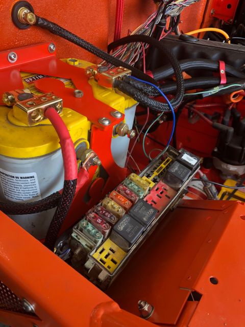 1992 Jeep Wrangler - The image shows a close-up view of a Jeep Wrangler's engine bay, focusing on the battery, fuse box, and wiring harness. A yellow Optima bat…