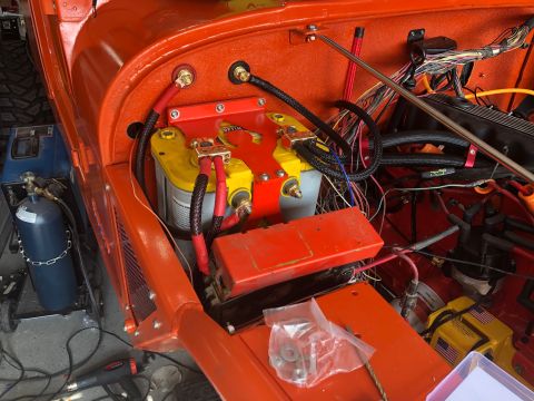 1992 Jeep Wrangler - The engine bay of an orange Jeep Wrangler shows a dual battery setup with Optima yellow top batteries. Various wiring, hoses, and engine co…