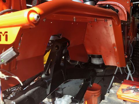 1992 Jeep Wrangler - The front driver's side fender and inner wheel well of an orange Jeep Wrangler are shown, with black suspension components visible undernea…