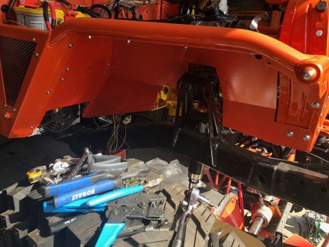 1992 Jeep Wrangler - An orange Jeep Wrangler fender is shown with visible rivets and a black inner fender liner. Tools and wiring are scattered on the ground be…