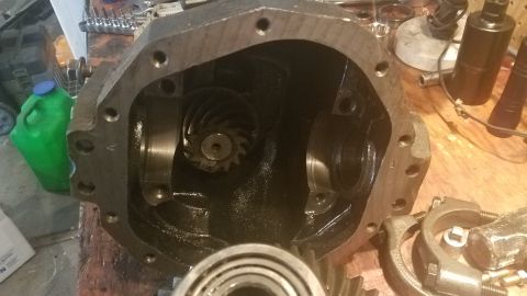 1985 Ford Bronco - The image shows the inside of a differential housing, likely from a 1985 Ford Bronco, with gears visible. Tools and a green plastic jug are…