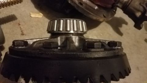 1985 Ford Bronco - A close-up view of a differential gear set with a bearing on top. The gear has teeth visible around its circumference and some text that re…