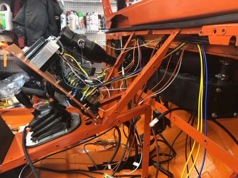 1992 Jeep Wrangler - The interior of an orange Jeep Wrangler is shown with a complex wiring harness being installed. Visible components include the steering col…
