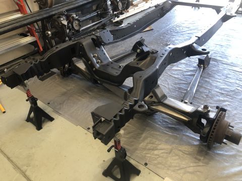 1979 Ford Bronco - A vehicle frame is shown on jack stands, with the front suspension components visible.