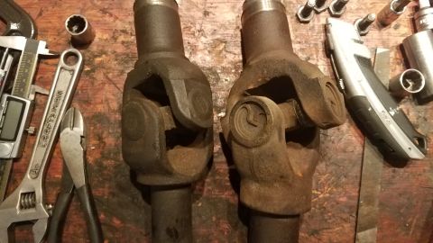 1985 Ford Bronco - A close-up view of two universal joints, surrounded by various tools, suggesting a repair or maintenance task.