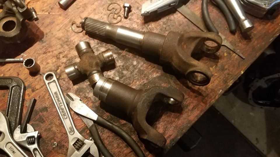 Driveshaft U-joint and yoke on workbench with tools