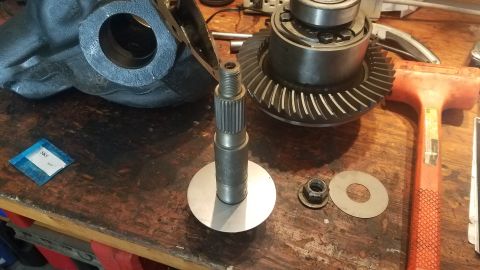 1985 Ford Bronco - Differential components laid out on a workbench, including gears, a shaft, and a housing.