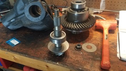 1985 Ford Bronco - Differential components laid out on a workbench, including gears, a pinion shaft, and a housing.