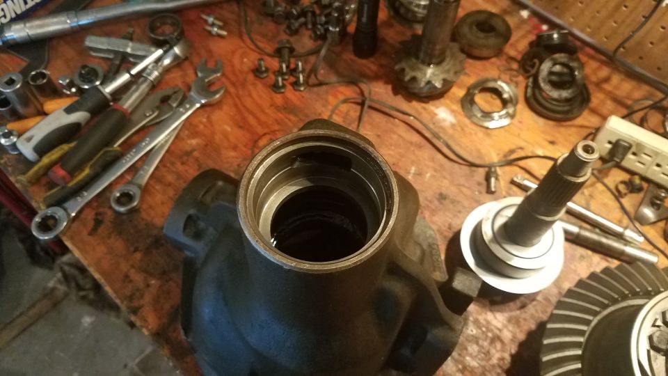Differential housing and gears spread out on a workbench with tools