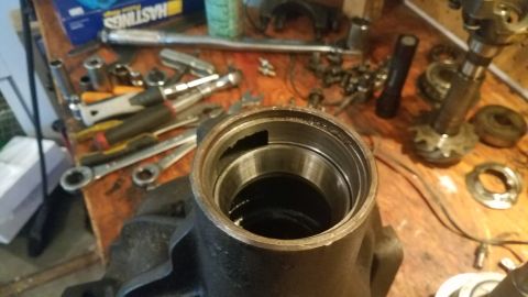 1985 Ford Bronco - A differential housing sits on a workbench surrounded by various tools, including wrenches and sockets.