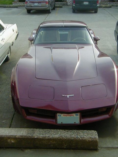 1993 Ford Bronco - Maroon Chevrolet Corvette parked in a lot, showing its distinctive front end and hood design.