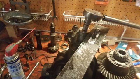 1985 Ford Bronco - Differential gears and associated tools are laid out on a workbench, suggesting a repair or assembly process.