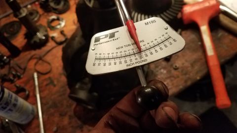 1985 Ford Bronco - A torque wrench is used to measure force on automotive differential parts, with a red hammer in the background.