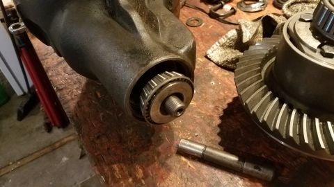 1985 Ford Bronco - Differential housing and ring gear components on a wooden workbench.