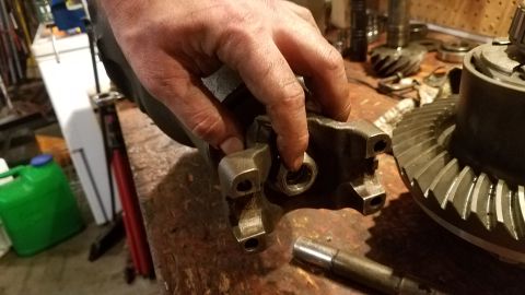 1985 Ford Bronco - Close-up of differential components and a hand manipulating a part on a workbench.