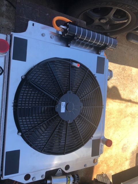 1992 Jeep Wrangler - Aftermarket radiator assembly an electric cooling fan and an oil cooler with a distinctive orange hose.