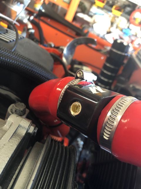 1992 Jeep Wrangler - A close-up view of a red hose secured by a clamp with K&N branding in a vehicle's engine compartment.